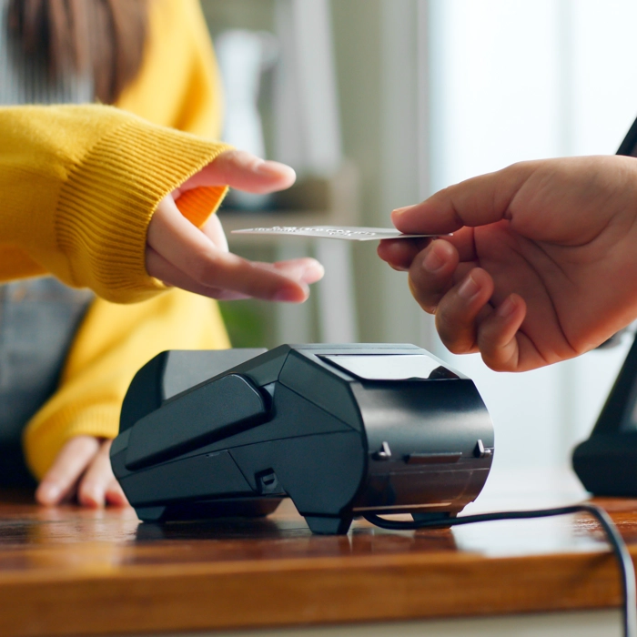 Person handing over card to pay at bakery Person handing over card to pay at bakery
