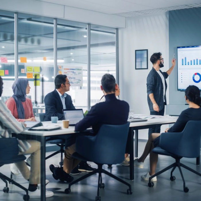 People sitting around room and talking about data People sitting around room and talking about data